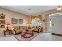 Well-lit living room features neutral tones, elegant decor, and white tile flooring at 2605 Daulby St, Kissimmee, FL 34747