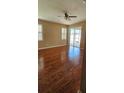 Bright living room featuring hardwood floors, plantation shutters, and sliding glass doors at 2752 Bellewater Pl, Oviedo, FL 32765