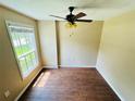 Cozy room with wood-look floors, a ceiling fan, and a large window letting in natural light at 276 Celebration Blvd, Celebration, FL 34747