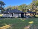View of the rear of the home featuring a screened-in pool and well-maintained backyard at 3064 S Us Highway 41, Dunnellon, FL 34432