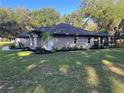Spacious home with a large yard, showcasing the side elevation and lush greenery around the property at 3064 S Us Highway 41, Dunnellon, FL 34432
