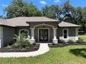 Inviting front entrance with glass double doors framed by elegant columns and manicured landscaping at 3064 S Us Highway 41, Dunnellon, FL 34432