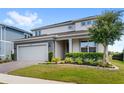 Charming two-story home with a brick driveway, manicured lawn, and stone accents at 3294 Hanging Tide St, Winter Garden, FL 34787
