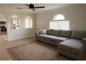Bright living room featuring an oversized couch, light wood floors, and arched doorways at 358 Fairfield Dr, Sanford, FL 32771
