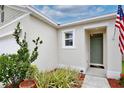 Inviting home entrance featuring neat landscaping, a welcome mat, and a stylish front door at 3945 Angola Ln, Sanford, FL 32771