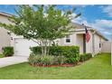 Attractive home with a tidy lawn, a decorative tree, and an American flag waving near the entrance at 3945 Angola Ln, Sanford, FL 32771