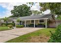 Home exterior featuring a covered porch, well-kept lawn, and landscaped front yard in a beautiful neighborhood at 417 Carvell Dr, Winter Park, FL 32792