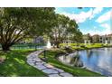 Picturesque pond with a fountain, green lawns, stone paths, and charming white gazebos at 4225 Thornbriar Ln # 305, Orlando, FL 32822