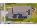 Aerial view shows solar panels on roof, lawn, and nearby playground at 4432 Seven Canyons Dr, Kissimmee, FL 34746