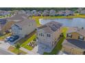 Aerial view of home with solar panels, lush lawn, water views, and neighborhood at 4432 Seven Canyons Dr, Kissimmee, FL 34746