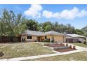 Well-maintained single story house featuring stone accents, mature landscaping and an attached two-car garage at 448 Sundown Trl, Casselberry, FL 32707