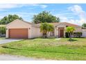 Charming single-story home with a well-maintained lawn, lovely palm trees, and two-car garage at 504 Delido Way, Kissimmee, FL 34758