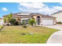 Inviting single-story home with manicured lawn, solar panels and a brick-paved driveway at 5113 Sage Way, Kissimmee, FL 34758