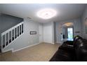 Open-concept living area with tile flooring, view of stairs, and a comfortable seating area with an entertainment center at 613 Casa Park Court B N Ct # B, Winter Springs, FL 32708