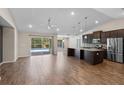 Open-concept living area with wood floors and a kitchen view, leading to a pool through sliding glass doors at 7017 Bridle Path, St Cloud, FL 34771