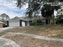 Single-story home featuring a well-manicured front yard, side yard, and attached garage at 7614 Brisbane Ct, Orlando, FL 32835
