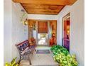 Cozy front porch with a bench, decorative plants, and a charming entrance door with glass panels at 9 Abbey Ct, Haines City, FL 33844