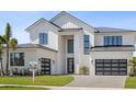 Charming two-story home with lush landscaping, black-trimmed windows, and a modern garage at 9155 Sheen Sound St, Orlando, FL 32836