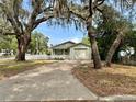 A charming single story home with mature landscaping and a white picket fence at 1040 N Clayton St, Mount Dora, FL 32757