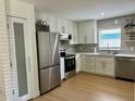 Modern kitchen with stainless steel appliances, white cabinets, and stylish backsplash at 1040 N Clayton St, Mount Dora, FL 32757