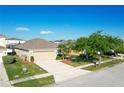 Well-maintained home with a large driveway, two-car garage, and mature landscaping at 1175 Seasons Blvd, Kissimmee, FL 34746