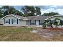 Charming single-story home featuring neutral siding, dark shutters, manicured landscaping and a well-maintained lawn at 131 Lake Charles Rd, Deland, FL 32724