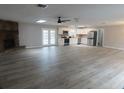 Open-concept living room featuring a stone fireplace, ceiling fan, skylights, gray walls, and wood-look flooring at 131 Lake Charles Rd, Deland, FL 32724