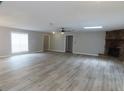 Spacious living room with gray walls, wood-look flooring, lots of natural light and a stone fireplace at 131 Lake Charles Rd, Deland, FL 32724