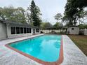 Inviting pool area with covered patio and storage shed, perfect for outdoor entertaining at 1329 Se 36Th Ave, Ocala, FL 34471