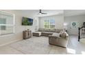 Bright living room featuring a large gray sectional sofa, and a wall-mounted TV at 13748 Werrington Dr, Winter Garden, FL 34787
