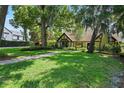 Home exterior with lush lawn, mature trees, and a brick pathway leading to the front entrance at 1742 Barcelona Way, Winter Park, FL 32789