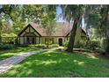 Charming home with well-manicured lawn and pathway leading to the front door, shaded by mature trees at 1742 Barcelona Way, Winter Park, FL 32789
