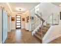 Bright and modern foyer with hardwood floors, glass-railed staircase, and elegant lighting at 1831 Mizell Ave, Winter Park, FL 32789
