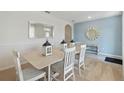 Dining room with seating for six, decorative mirrors, modern flooring, and soft, inviting colors at 2155 Kalin Way, Tavares, FL 32778