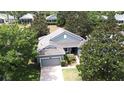 An aerial view of the home displaying the roof, yard, and mature trees surrounding the property at 2503 Squaw Crk, Clermont, FL 34711
