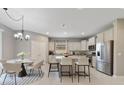 Bright eat-in kitchen features stainless steel appliances, an island with seating, and elegant light fixture at 3629 Vega Creek Dr, St Cloud, FL 34772