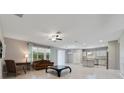 Spacious living room featuring tile floors, a fan, and seamless transition to the modern kitchen at 3629 Vega Creek Dr, St Cloud, FL 34772