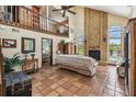 Cozy living room with a brick fireplace, terracotta tile flooring, and views of the upper level loft at 383 Brushwood Ln, Winter Springs, FL 32708