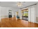 Bright living room with hardwood floors, a fireplace, and sliding doors leading to a screened porch at 3928 Villas Green Cir, Longwood, FL 32779