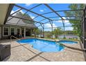 Stunning screened-in pool and spa with a serene lake view, perfect for relaxation and outdoor entertaining at 5108 Sailwind Cir, Orlando, FL 32810