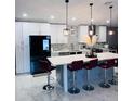 Modern kitchen with white cabinets, stainless steel appliances, a center island with barstool seating, and marble tile floors at 6216 Beaumont Ave, Orlando, FL 32808