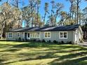 Charming single-story home with a well-maintained lawn and a backdrop of mature trees at 7374 Circle Dr, Lady Lake, FL 32159