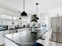 Bright kitchen featuring an island with black marble countertops, white cabinets, and stainless steel appliances at 7374 Circle Dr, Lady Lake, FL 32159