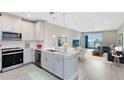 Open concept kitchen flows into a living room with a sliding glass door to a balcony and water views at 7565 Laureate Blvd # 3408, Orlando, FL 32827