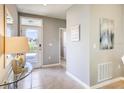 Inviting entryway with a glass-topped console table, neutral-toned walls, and a view of the front door at 8383 Madrid St, Lakeland, FL 33810