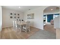 Bright dining area with stylish decor, white wainscoting, neutral carpet, and a view of the living area at 947 Princess Sabal Pt, Haines City, FL 33844