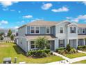Charming two-story exterior with light blue siding, a well-manicured lawn, and lush landscaping at 10940 Leafshore Loop, Orlando, FL 32829