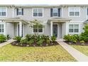Charming townhome entrance with manicured landscaping and inviting curb appeal and blue door at 11607 Sunsail Ave, Orlando, FL 32832