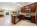 Modern kitchen featuring stainless steel appliances, granite countertops, and a seamless transition into the dining area at 11908 Fiore Dr # 1, Orlando, FL 32827