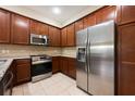 Stylish kitchen boasting stainless steel appliances, granite countertops, and ample dark wood cabinetry for storage at 11908 Fiore Dr # 1, Orlando, FL 32827